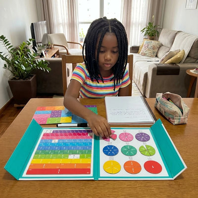Menina montando fração no livro magnético Pizza Math aberto na mesa da sala