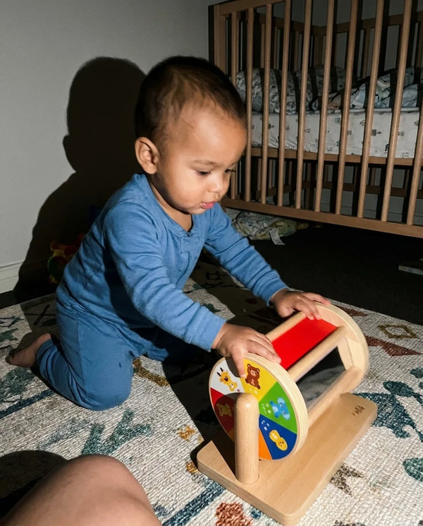Bebe empurrando o Tumble Kids no quarto