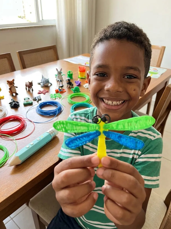 Menino mostrando libelula 3D feita com a caneta Air Pen