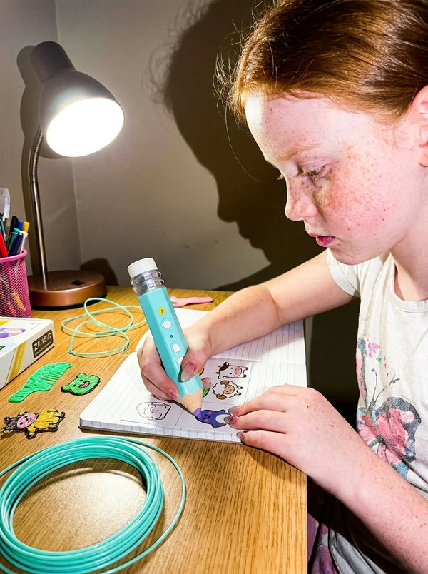 Menina desenhando com a caneta 3D Air Pen na mesa de estudo a noite