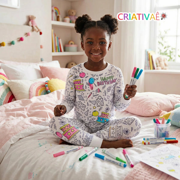 Menina sentada na cama vestindo o Pijama Mágico Criativaê tema Aniversário com bolos e balões coloridos